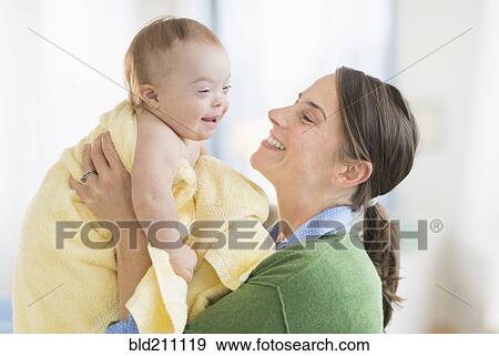 Stock Photo - Caucasian mother toweling baby girl with Down Syndrome. Fotosearch