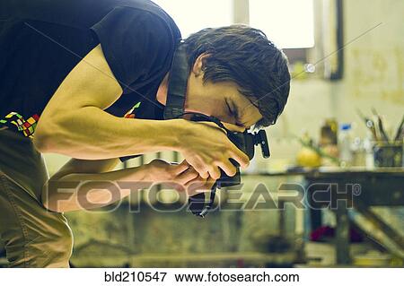 Stock Photo - Caucasian photographer working in studio. Fotosearch
