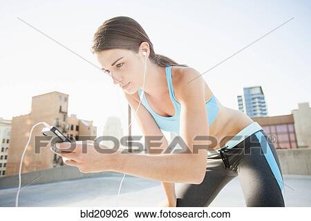 Stock Photograph - Caucasian runner listening to headphones. Fotosearch
