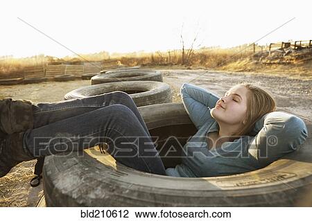 Caucasian teenage girl sitting in empty tire View Large Photo Image Stock Image - Caucasian teenage girl sitting in empty tire. Fotosearch