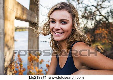 Stock Image - Caucasian teenage girl smiling outdoors. Fotosearch