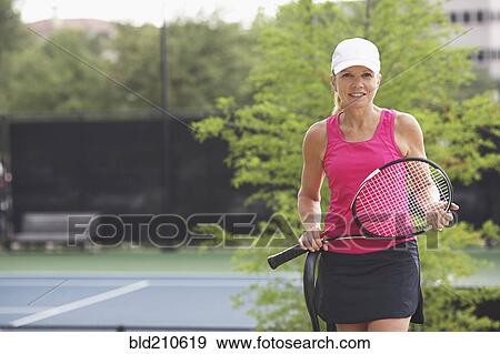 Stock Photo - Caucasian tennis player standing on court. Fotosearch