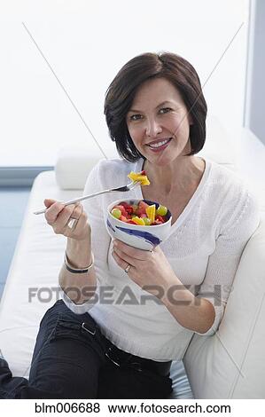 Stock Photo - Caucasian woman eating fruit salad. Fotosearch
