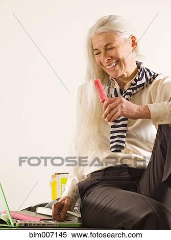 Stock Photography - Caucasian woman enjoying popsicle. Fotosearch