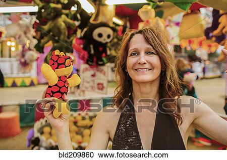 Caucasian woman holding toy at amusement park View Large Photo Image Stock Image - Caucasian woman holding toy at amusement park. Fotosearch