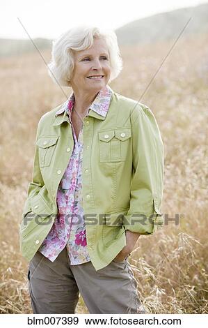 Caucasian woman in field with hands in pockets View Large Photo Image Stock Photo - Caucasian woman in field with hands in pockets. Fotosearch