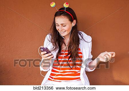 Caucasian woman in novelty antenna listening to mp3 player View Large Photo Image Stock Photograph - Caucasian woman in novelty antenna listening to mp3 player. Fotosearch