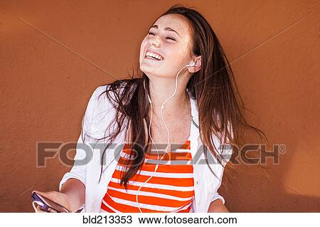 Caucasian woman listening to mp3 player View Large Photo Image Stock Image - Caucasian woman listening to mp3 player. Fotosearch