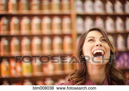 Stock Photo - Caucasian woman looking up and laughing. Fotosearch