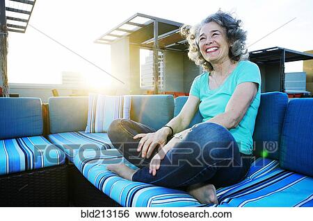 Stock Photograph - Caucasian woman relaxing on urban rooftop. Fotosearch