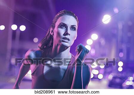 Stock Image - Caucasian woman running on city street. Fotosearch