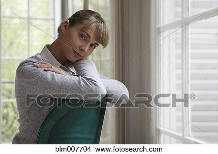 Caucasian woman sitting in chair View Large Photo Image Picture - Caucasian woman sitting in chair. Fotosearch