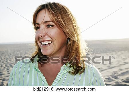 Stock Photograph - Caucasian woman smiling on beach. Fotosearch