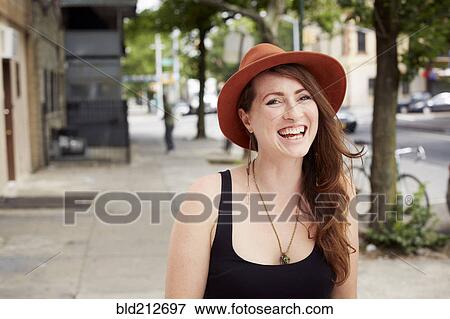 Stock Photo - Caucasian woman smiling on city street. Fotosearch