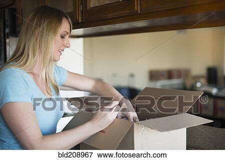 Caucasian woman unpacking in new home View Large Photo Image Stock Photo - Caucasian woman unpacking in new home. Fotosearch