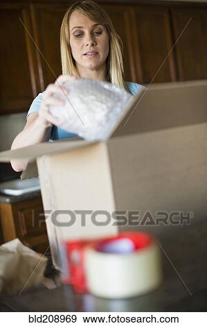 Caucasian woman unpacking in new home View Large Photo Image Stock Photo - Caucasian woman unpacking in new home. Fotosearch