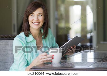 Picture - Caucasian woman using digital tablet. Fotosearch