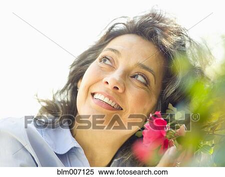 Caucasian woman with flower outdoors View Large Photo Image Stock Photography - Caucasian woman with flower outdoors. Fotosearch