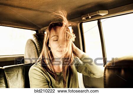 Stock Image - Caucasian woman's hair blowing in car. Fotosearch