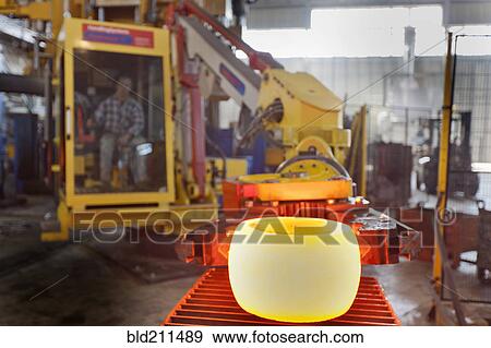 Stock Photo - Caucasian worker operating steel melting machinery in factory. Fotosearch