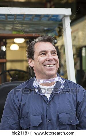 Caucasian worker smiling in warehouse View Large Photo Image Stock Image - Caucasian worker smiling in warehouse. Fotosearch