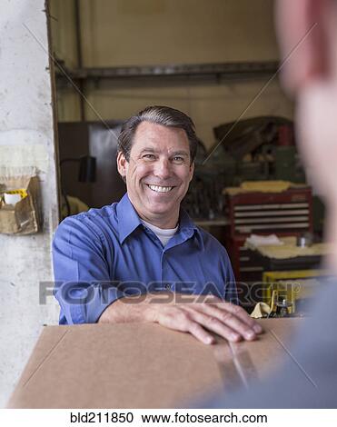 Caucasian workers smiling in warehouse View Large Photo Image Stock Image - Caucasian workers smiling in warehouse. Fotosearch
