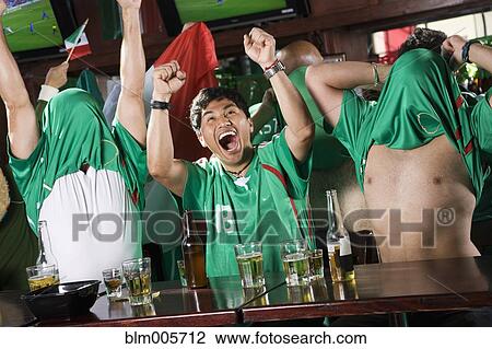 Stock Image - Cheering men watching television in sports bar. Fotosearch