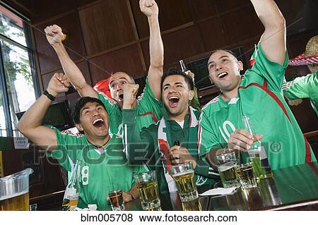 Stock Photo - Cheering men watching television in sports bar. Fotosearch