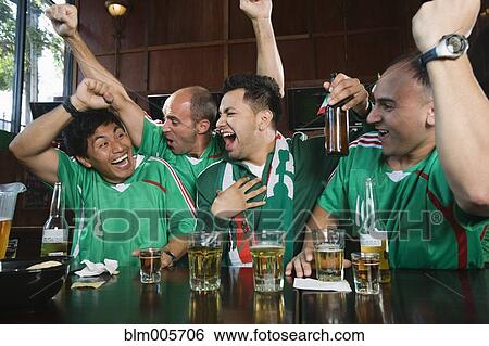 Cheering men watching television in sports bar View Large Photo Image Stock Photograph - Cheering men watching television in sports bar. Fotosearch