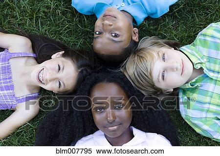 Children laying in formation on grass View Large Photo Image Stock Photography - Children laying in formation on grass. Fotosearch