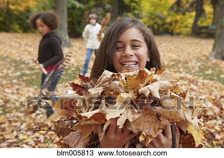Children raking autumn leaves View Large Photo Image Stock Image - Children raking autumn leaves. Fotosearch