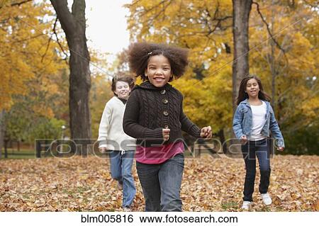 Children running in park in autumn View Large Photo Image Stock Photograph - Children running in park in autumn. Fotosearch