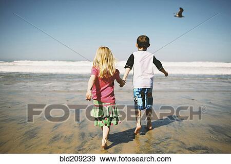 Children walking together on beach View Large Photo Image Stock Photo - Children walking together on beach. Fotosearch