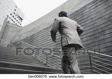 Stock Photograph - Chinese businessman running up stairs. Fotosearch