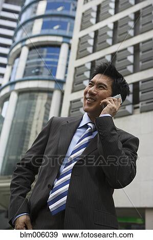 Stock Photo - Chinese businessman talking on cell phone. Fotosearch