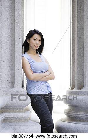 Chinese businesswoman leaning against stone pillar View Large Photo Image Picture - Chinese businesswoman leaning against stone pillar. Fotosearch