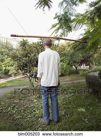 Chinese man balancing stick on head View Large Photo Image Stock Image - Chinese man balancing stick on head. Fotosearch
