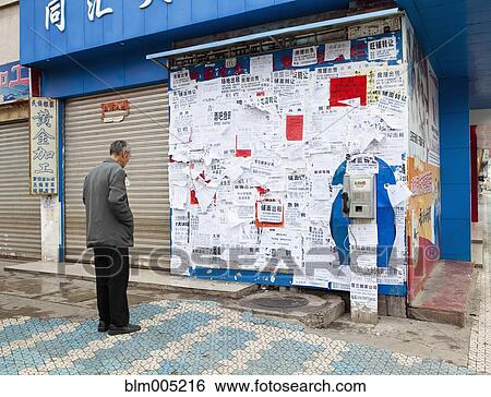 Chinese man reading posters on wall View Large Photo Image Stock Photograph - Chinese man reading posters on wall. Fotosearch