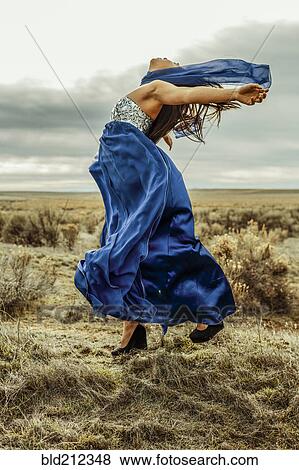 Stock Photo - Chinese teenage girl playing with scarf in rural field. Fotosearch