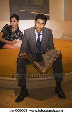 Stock Image - Chinese woman sitting on round bed with husband. Fotosearch