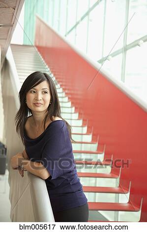 Stock Photo - Chinese woman standing on staircase. Fotosearch