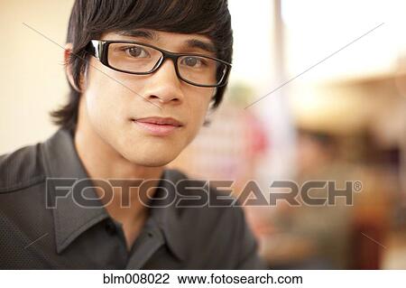 Stock Image - Close up of mixed race man with eyeglasses. Fotosearch