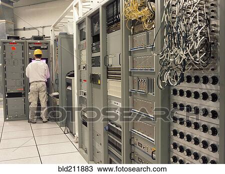Stock Image - Computer programmer working in server room. Fotosearch