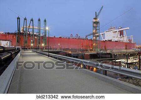 Stock Image - Concrete walkway to container ship in shipyard. Fotosearch
