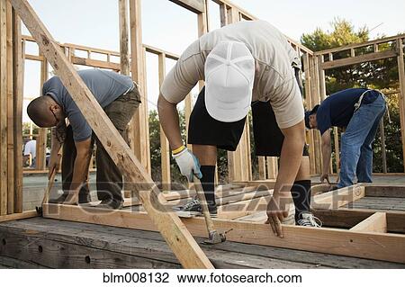 Construction workers building house frame View Large Photo Image Stock Image - Construction workers building house frame. Fotosearch