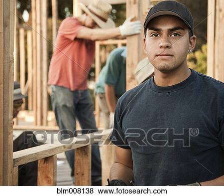 Stock Photo - Construction workers working on house frame. Fotosearch