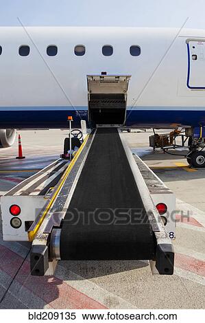 Stock Photography - Conveyor belt by airplane cargo hold. Fotosearch