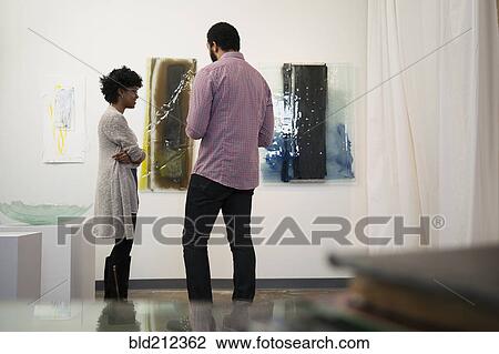 Stock Image - Couple admiring art in gallery. Fotosearch