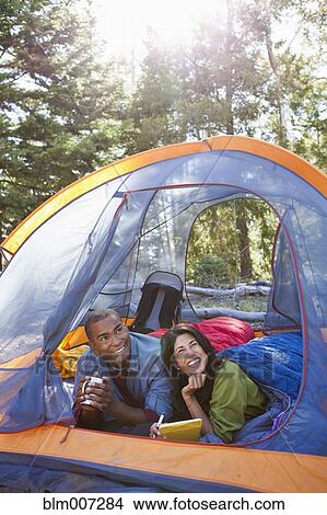 Picture - Couple camping and laying in tent. Fotosearch