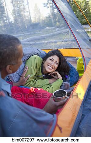 Stock Photo - Couple camping and laying in tent. Fotosearch